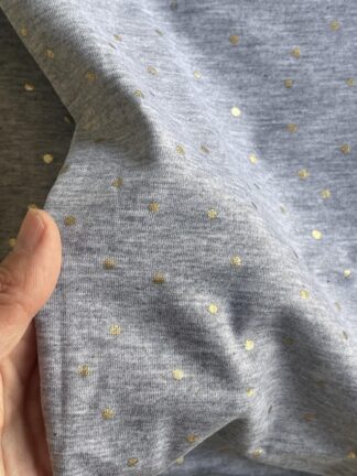 Tejido de punto gris melange con puntitos dorados
